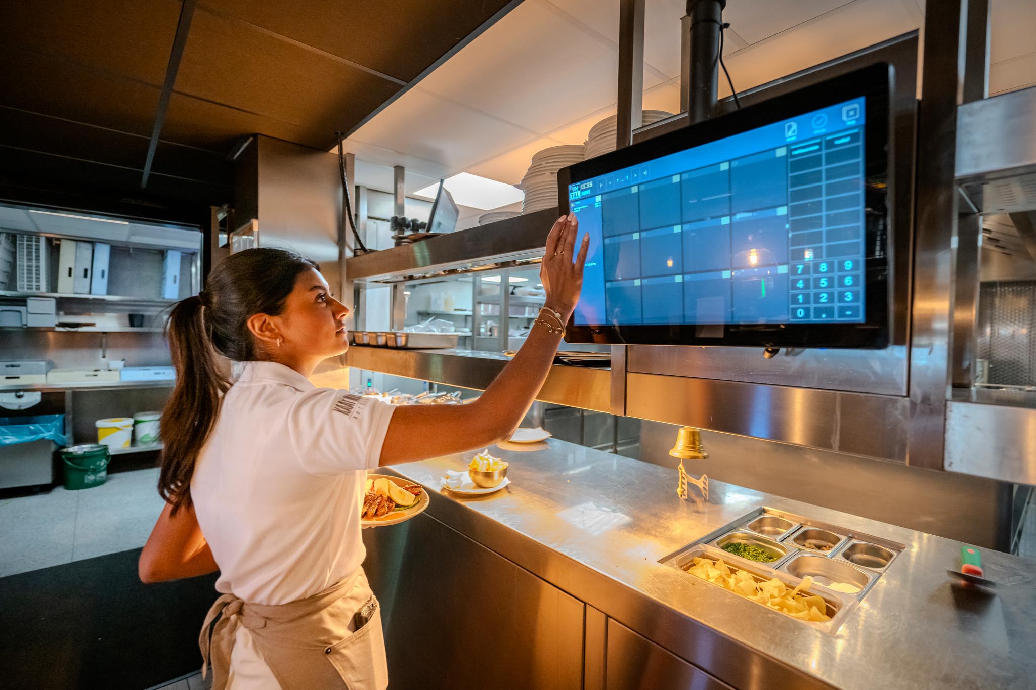 Bediening bij een pickup-scherm in het restaurant van Kaat Mossel in Rotterdam